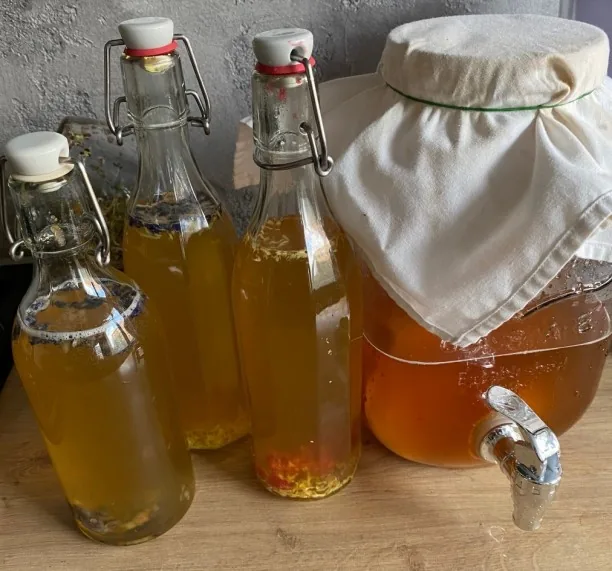 Lahve s fermentovanými limonádami a nádoba s kohoutkem